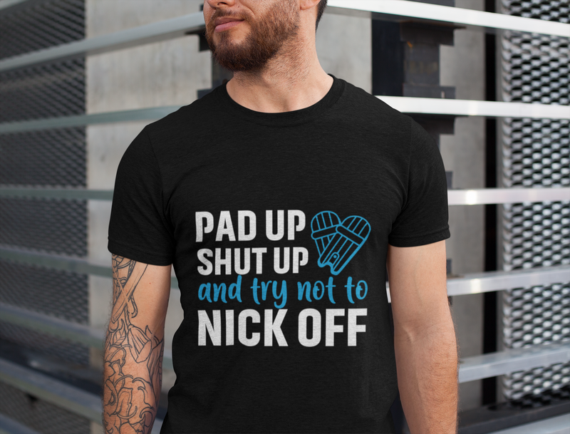 A man wearing a black t-shirt with Pad Up, Shut Up And Try Not To Nick Off on the front. A Funny Cricket Tee, Premium Fabric, Multiple Adult Sizes
