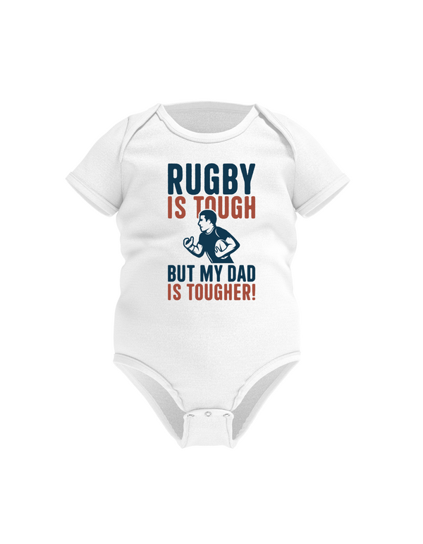 White baby onesie with rugby-themed text on a white background with a Cows Corner slogan saying Rugby is tough, but my dad is tougher