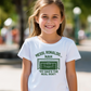 A little girl wearing a white t-shirt with the funny football and dad loving slogan on the front which reads 'Messi, Ronaldo…Nah ’My Dads the Real Goat!'