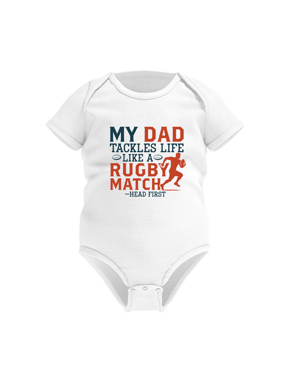 White baby onesie with colorful text on a white background with the Cows Corner slogan saying My dad tackles life like a rugby match - head first.