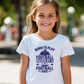 A girl wearing a white t-shirt with the funny football saying that says I love my dad 'Born To Play Football. Raised by a Football Dad!'