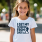 A young girl wearing a t-shirt with the funny football slogan on the front saying 'I Get My Tekkers From Dad'