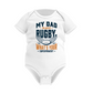 White baby onesie with rugby-themed text on a white background, with a slogan on the front saying 'My Dad Plays Rugby. What’s Your Superpower?
