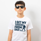 A young boy wearing a t-shirt with the funny football slogan on the front saying 'I Get My Tekkers From Dad'