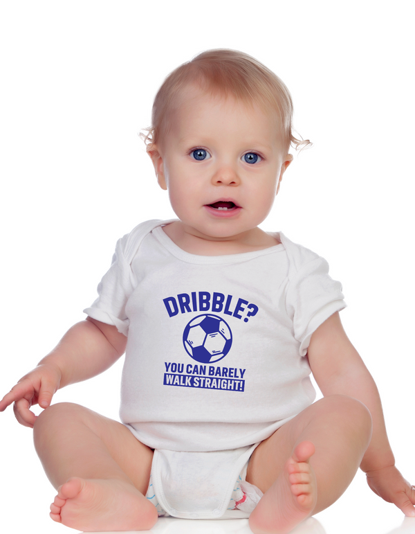 A little baby wearing a white baby grow with a funny football slogan on the front that reads 'Dribble You Can Barely Walk Straight!'
