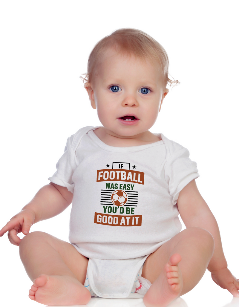 A baby wearing a white baby grow with the funny football slogan on the front that reads 'If Football Was Easy You’d Be Good at It'