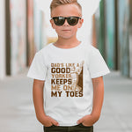 A little girl wearing a white t-shirt with Dads Like A Good Yorker, Keeps Me On My Toes on the front. A Funny Cricket T-Shirt, Premium Fabric, Multiple Junior Sizes, Perfect for Boys and Girls