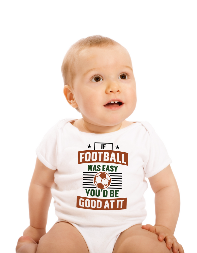 A baby wearing a white baby grow with the funny football slogan on the front that reads 'If Football Was Easy You’d Be Good at It'
