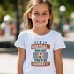 A little girl wearing a white T-shirt with the funny football slogan on the front that reads 'If Football Was Easy You’d Be Good at It'