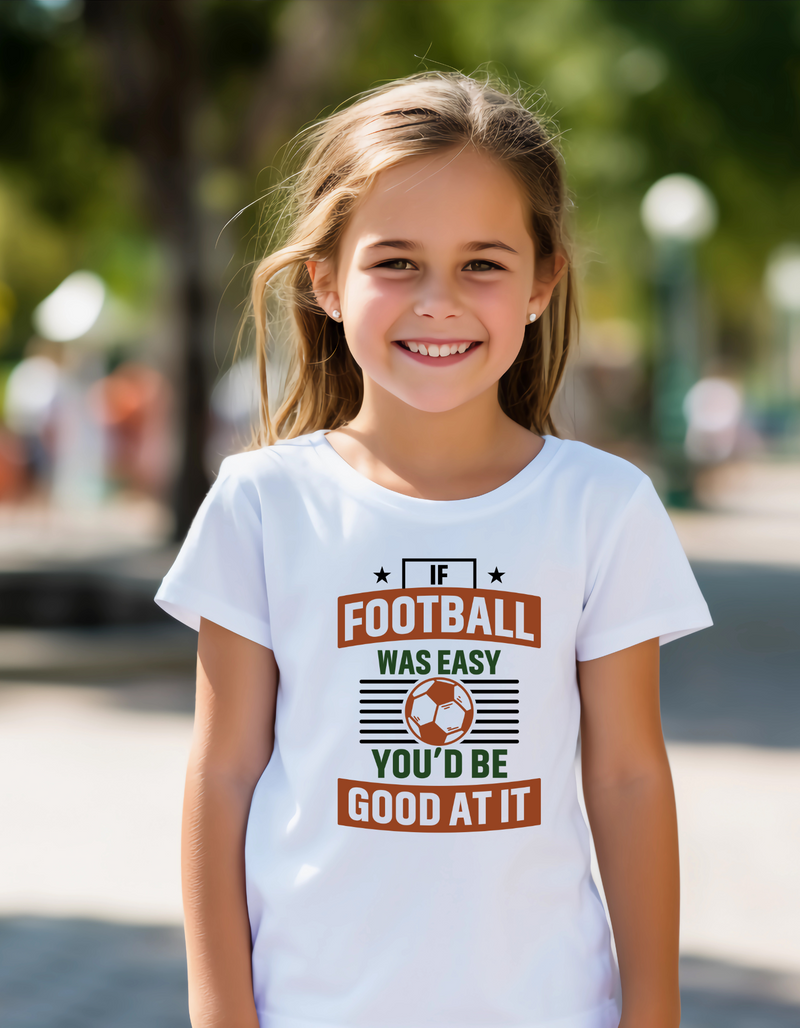 A little girl wearing a white T-shirt with the funny football slogan on the front that reads 'If Football Was Easy You’d Be Good at It'