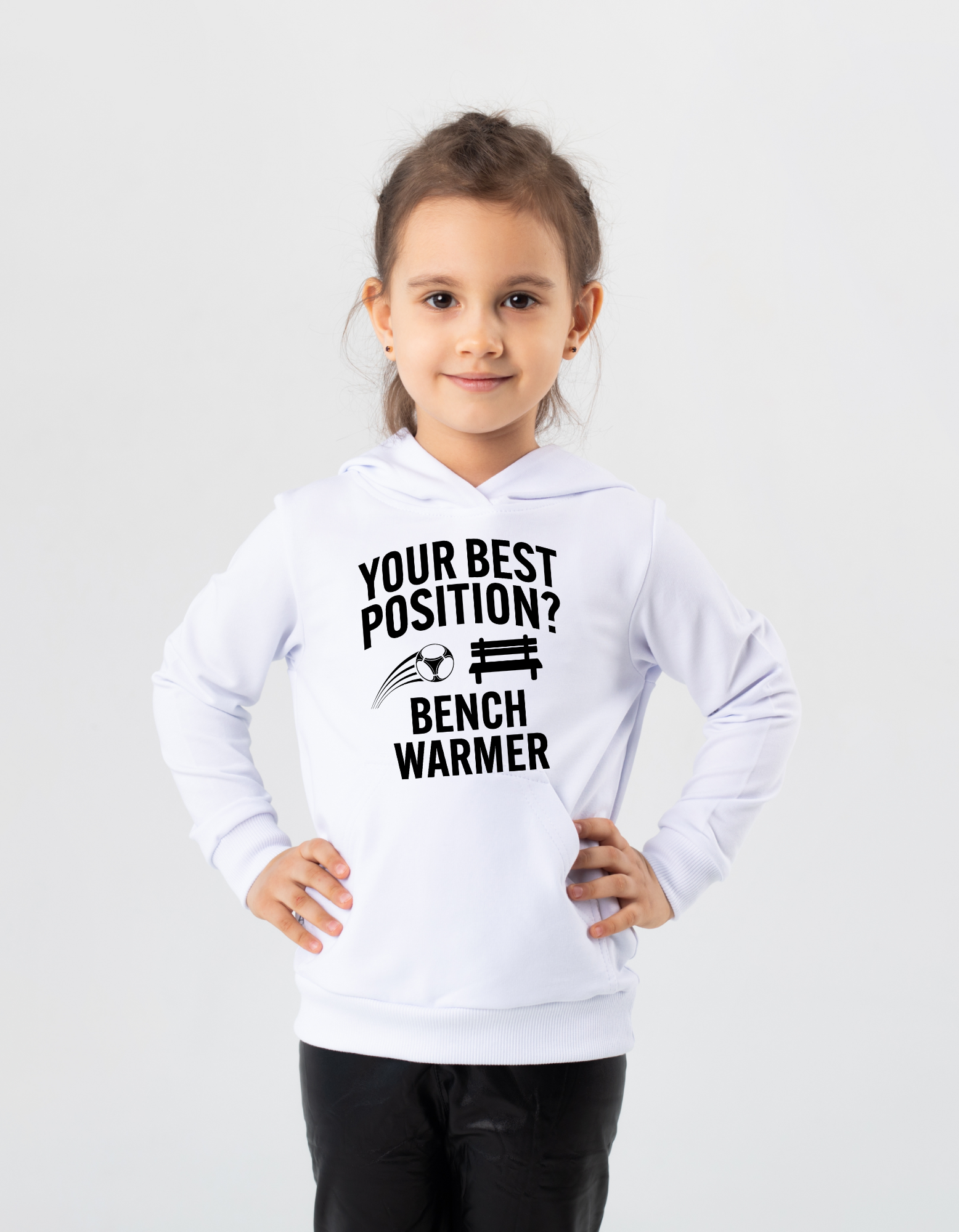 A girl wearing a white hoodie that has the funny football slogan on the front that reads 'Your Best Position? Bench Warmer'