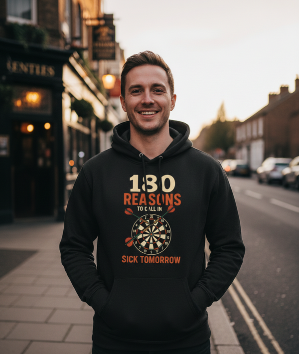 Man wearing a black hoodie with a humorous graphic and text on a street. The man is wearing a Cows Corner hoodie with the funny darts slogan '180 Reasons To Call In Sick Tomorrow'. Cows Corner gifts are perfect for sport-mad fans, these gifts work brilliantly for birthdays, new baby celebrations, Father’s Day, Mother’s Day, Christmas, anniversaries, thank you gifts, end-of-season team awards, graduations, retirements, and just-because moments when you want to raise a smile. 
