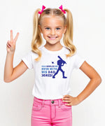 A little girl wearing a white t-shirt with Dad Bowled Me Over With His Dad Jokes on the front. A Funny Cricket T-shirt For Kids, Premium Fabric, Multiple Junior Sizes, Perfect For Boys And Girls