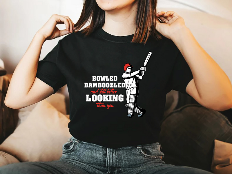 A lady wearing a black t-shirt with Bowled & Bamboozled and Still Looking Better Than You on the front. A Funny Cricket T-Shirt, Premium Fabric, Multiple adult Sizes