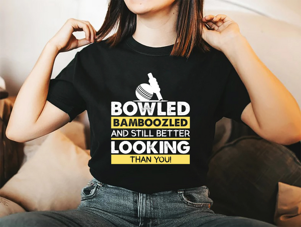 A lady wearing a black t-shirt with Bowled & Bamboozled and Still Looking Better Than You on the front. A Funny Cricket T-Shirt, Premium Fabric, Multiple Adult Sizes
