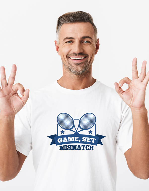 A man wearing a white t-shirt that has a funny tennis slogan on the front that reads 'Game, Set, Mismatch'
