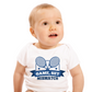A little baby wearing a white baby grow with the funny tennis slogan on the front that reads 'Game, Set, Mismatch'