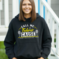 A lady wearing a black hoodie with the funny tennis slogan on the front that reads 'Call Me Federer ’Cause I Just Schooled You'