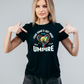 A lady wearing a black t-shirt with the funny tennis slogan on the front that reads 'Your Game's Got More Faults Than A Bad Umpire'