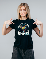 A lady wearing a black t-shirt with the funny tennis slogan on the front that reads 'Your Game's Got More Faults Than A Bad Umpire'