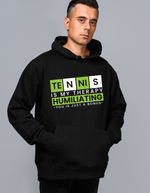 A man wearing a black hoodie with the funny tennis slogan on the front that reads 'Tennis Is My Therapy, Humiliating You Is Just A Bonus'
