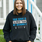 A lady wearing a black hoodie with the funny tennis slogan on the front which reads 'Your Serve Is Slower Than My Grandma's Wifi'