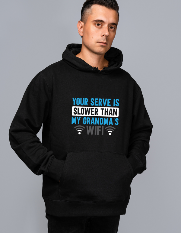 A man wearing a black hoodie with the funny tennis slogan on the front which reads 'Your Serve Is Slower Than My Grandma's Wifi'
