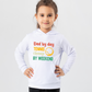 A little girl wearing a white hoodie with the funny tennis slogan on the front that reads 'Dad By Day, Tennis Champ By Weekend'
