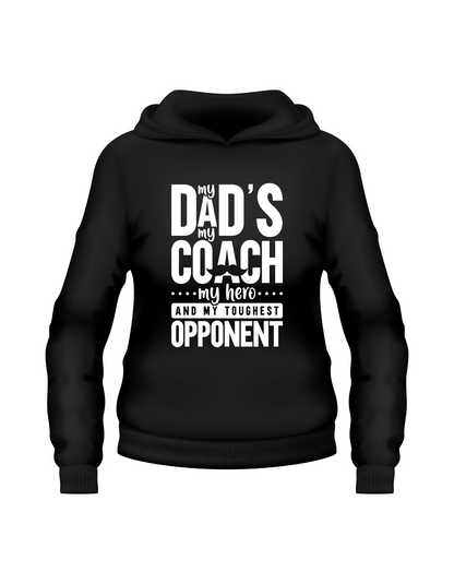 A black hoodie with the funny tennis slogan on the front that reads 'My Dads My Coach, My Hero And My Toughest Opponent'