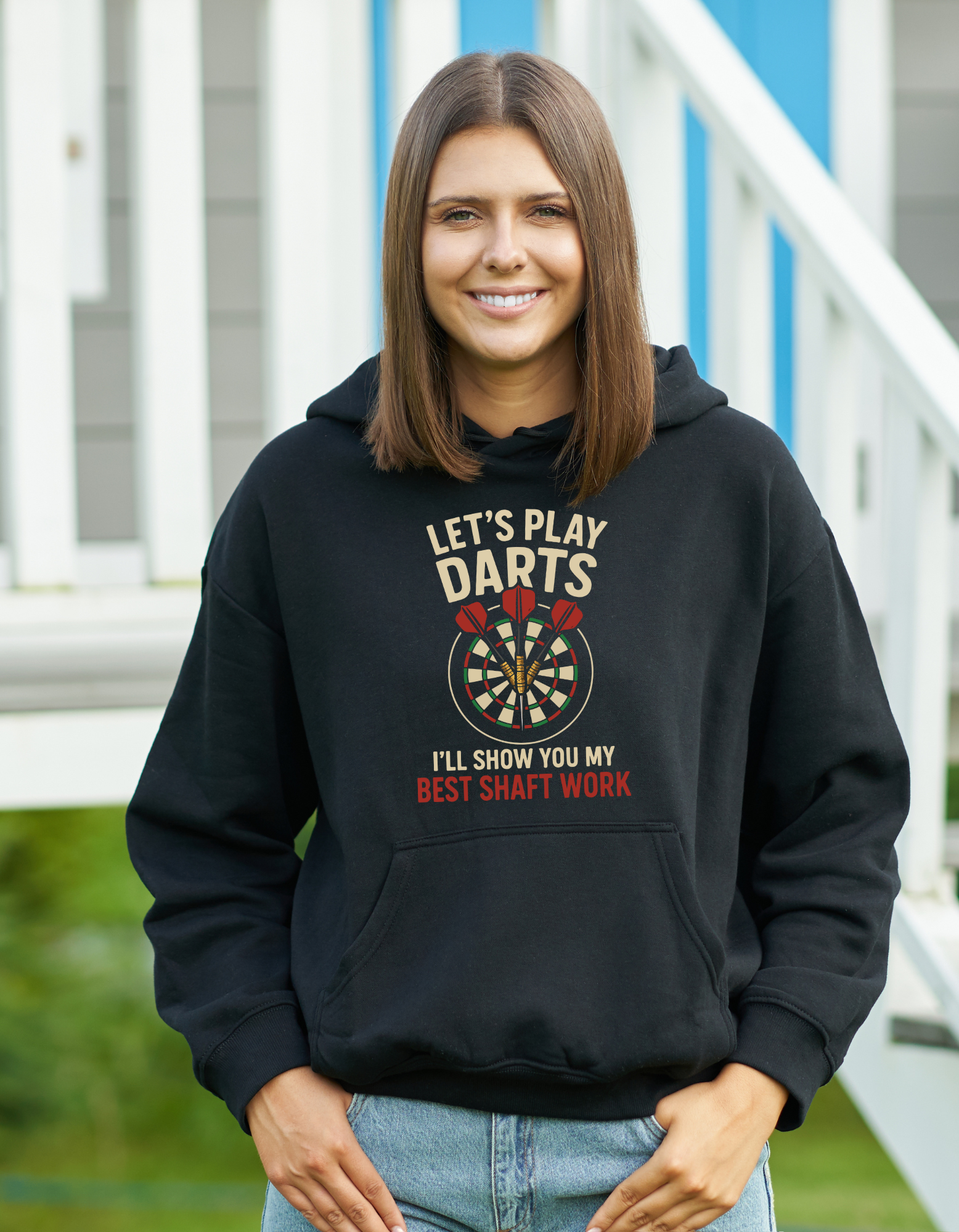 Person wearing a black hoodie with a dart-themed design outdoors with a Cows Corner slogan saying Let's play Darts I'll show you my best shaft work