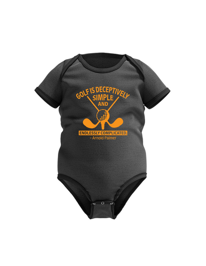 Gray baby onesie with yellow golf-themed design and text on a white background with a Cows Corner slogan saying Golf is deceptively simple and endlessley complicated - Arnold Palmer