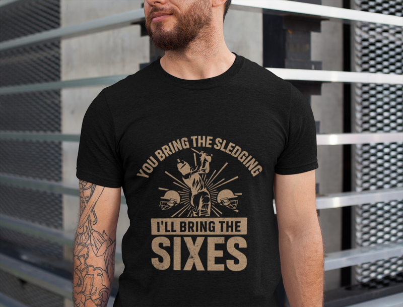 A man wearing a black t-shirt with You Bring The Sledging, I'll Bring The Sixes on the front. A Funny Cricket T-Shirt, Premium Fabric, Multiple Adult Sizes