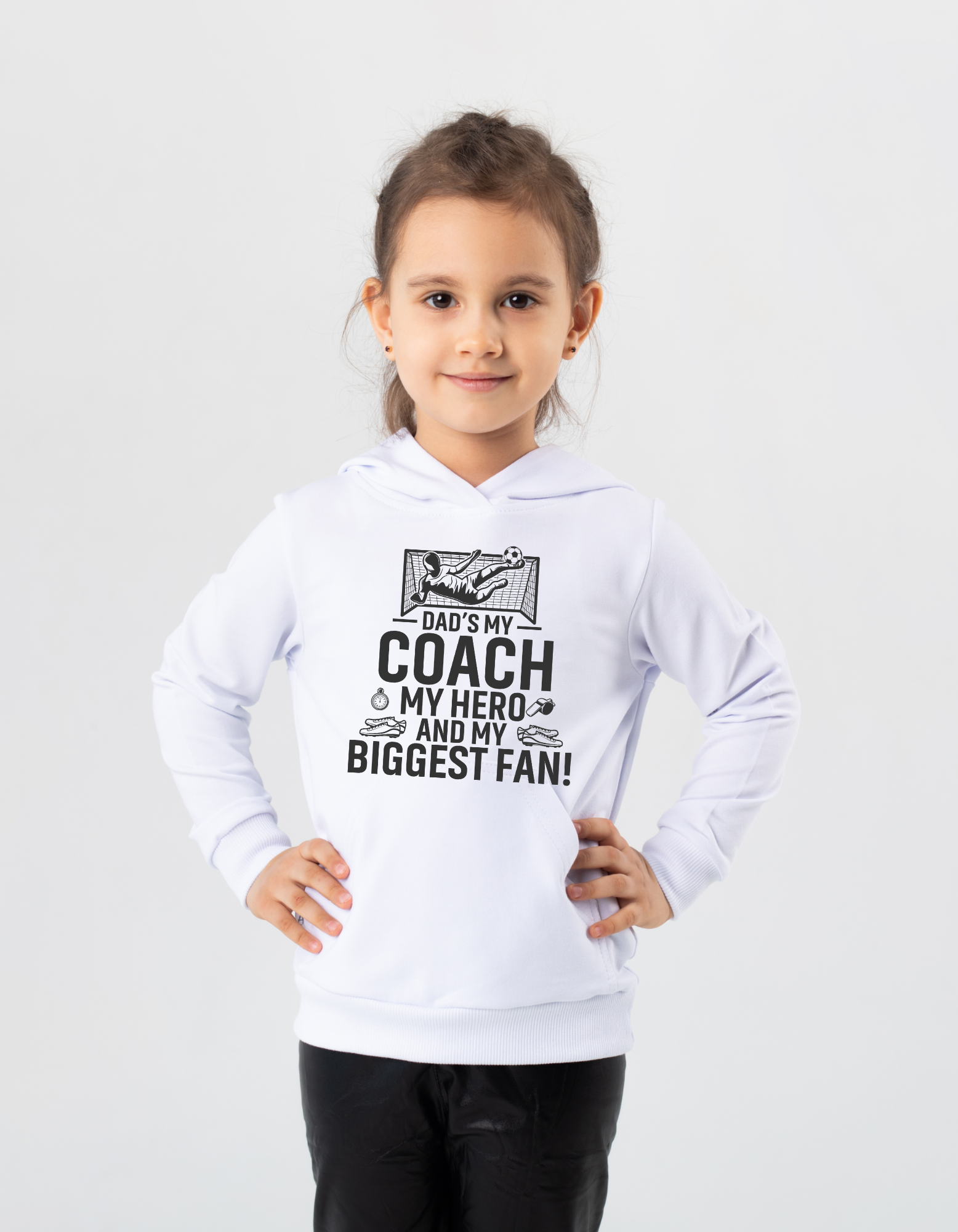 A little girl wearing a white hoodie with the funny football slogan on the front saying 'Messi, Ronaldo…Nah ’My Dads the Real Goat!