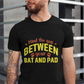 A man wearing a black t-shirt with Mind The Gap Between Your Bat And Pads on the front. A Funny Cricket T-Shirt, Premium Fabric, Multiple Adult Sizes