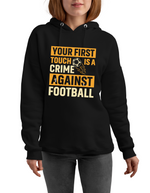 A lady wearing a black hoodie with the funny football slogan on the front that reads 'Your First Touch Is a Crime Against Football'