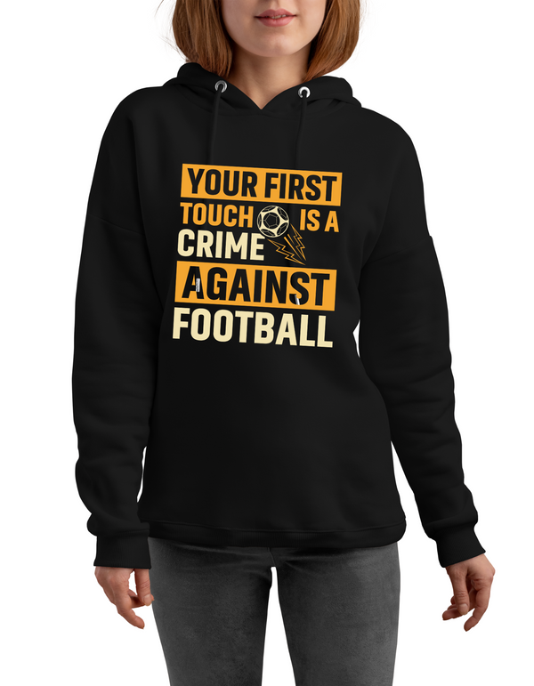A lady wearing a black hoodie with the funny football slogan on the front that reads 'Your First Touch Is a Crime Against Football'
