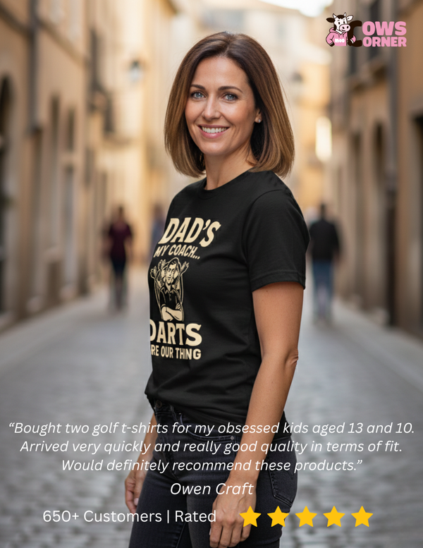 Woman wearing a black t-shirt with text on a street, featuring a product review. The lady is wearing one of Cows Corner funny sports slogan t-shirts with a customer review at the bottom that reads 'Bought two golf t-shirts for my obsessed kids aged 13 and 10. Arrived very quickly and really good quality in terms of fit. Would definitely recommend these products.'