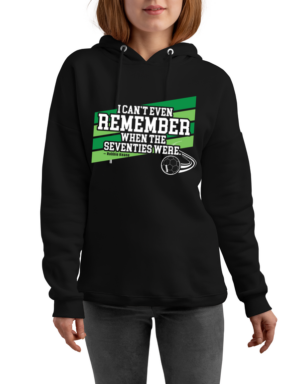 Person wearing a black hoodie with a colorful graphic and text on a white background with Cows Corner slogan I can't even remember when the seventies were - Robbie Keane