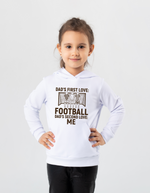 A young girl wearing a white hoodie with the funny football slogan on the front saying 'Dad’s First Love: Football. Dad’s Second Love: Me'