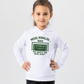 A little girl wearing a white hoodie with the funny football and dad loving slogan on the front which reads 'Messi, Ronaldo…Nah ’My Dads the Real Goat!'