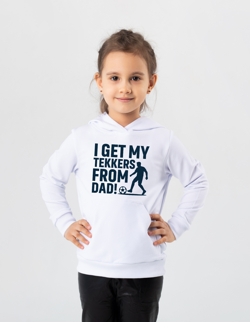 A young girl wearing a white hoodie with the funny football slogan on the front saying 'I Get My Tekkers From Dad'