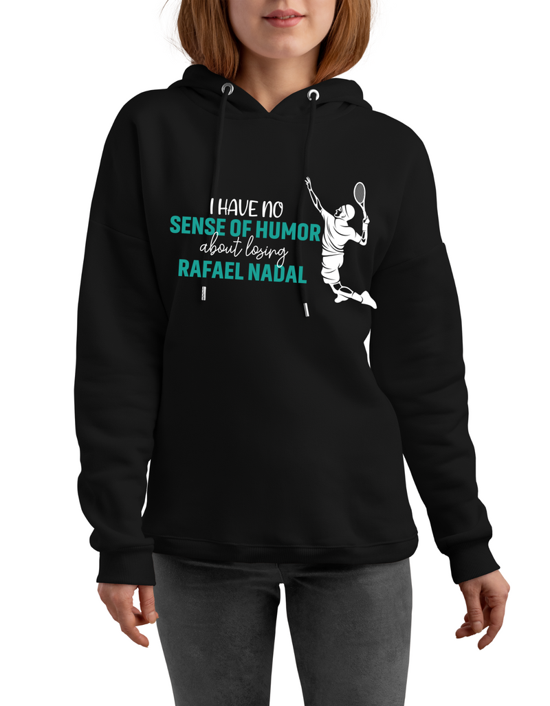 A lady wearing a black hoodie with 'I Have No Sense of Humour About Losing – Rafael Nadal' funny tennis slogan on the front