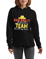 A lady wearing a black hoodie with the lovely tennis saying on the front that reads 'Dad and I? A Doubles Team Built on Love. '