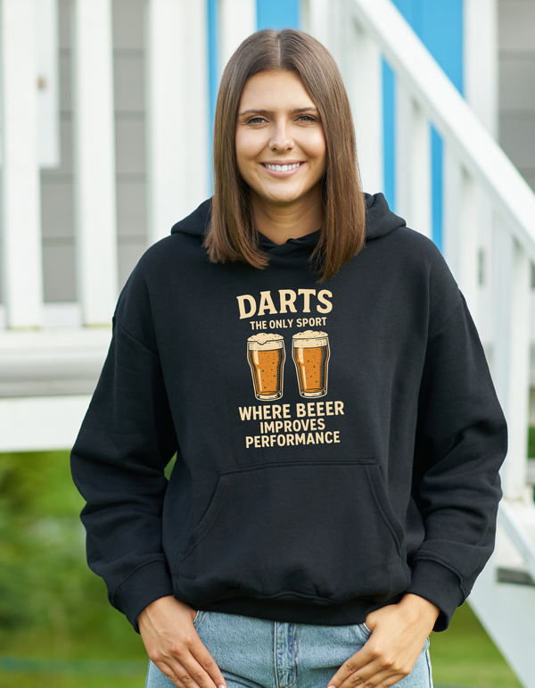 Woman wearing a black hoodie with a humorous darts and beer graphic with a Cows Corner slogan saying Darts the only sport where beeer improves performance.