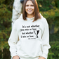 A lady wearing a white hoodie with the funny tennis slogan on the front reading 'It’s Not Whether You Win or Lose but Whether I Win or Lose – Billie Jean-King!