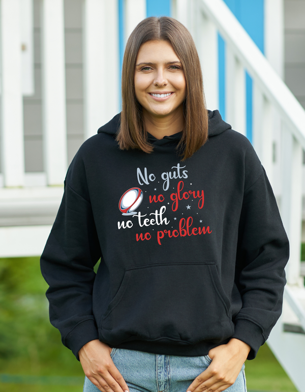 Woman wearing a black hoodie with a motivational quote outdoors with a Cows Corner slogan saying No guts no glory, no teeth no problem