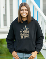 Person wearing a black hoodie with a graphic and text, standing outdoors, with slogan on the front saying 'We Might Be the Underdogs, but at Least We’ve Got Better Teeth – Scott Gibbs