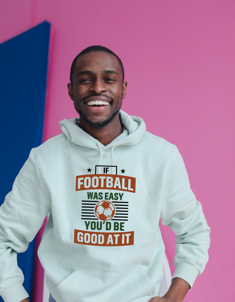 A man wearing a white hoodie with the funny football slogan on the front that reads 'If Football Was Easy You’d Be Good at It'