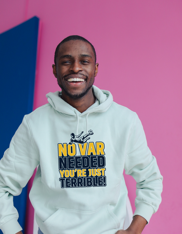 A man wearing a white t-shirt with the funny football slogan on the front that reads 'No VAR Needed You’re Just Terrible'