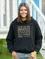 Person wearing a black hoodie with a humorous quote outdoors, with the slogan on the front 'We’re Not the Brightest Bunch in the World, but We’re Not As Daft as People Think – Brian O’Driscoll